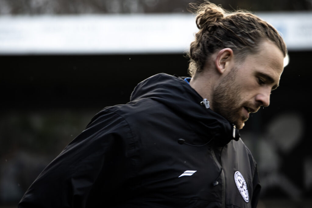 Player in a jacket on a football pitch