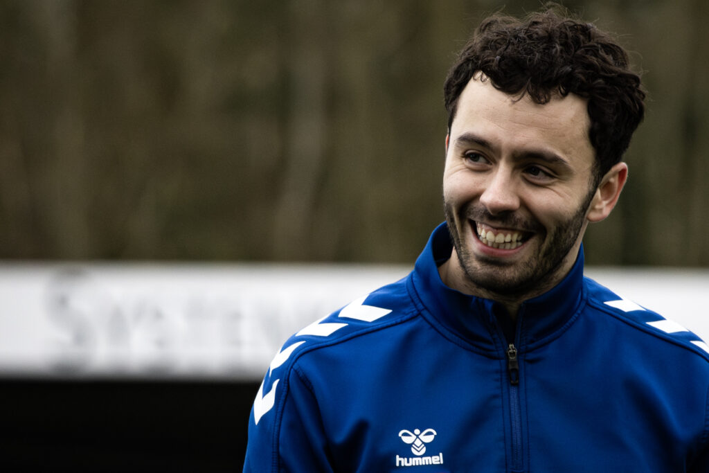 Football player in training kit smiling